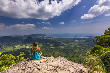 girl sitting on rock at daylight with mountains below