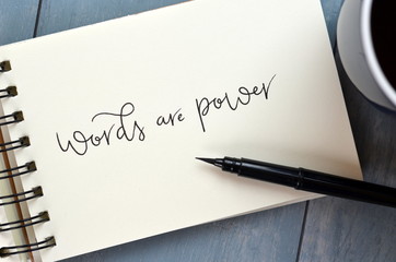 WORDS ARE POWER hand-lettered in notepad with cup of coffee on desk