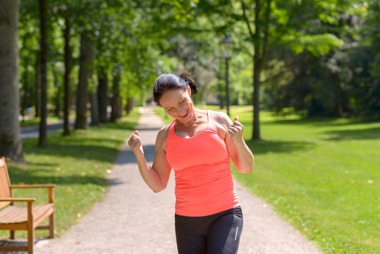 Enthusiastic mature woman running in park