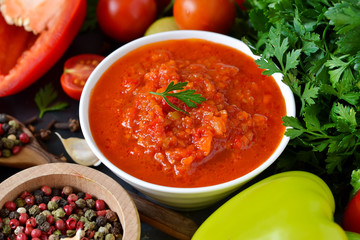 Tomato sauce with vegetables and spices on a black background. Sauce to pizza .Food background.
