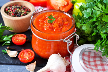 Adjika is a Georgian national sauce made of pepper, garlic and spices on a black background. Sauce. Food background.