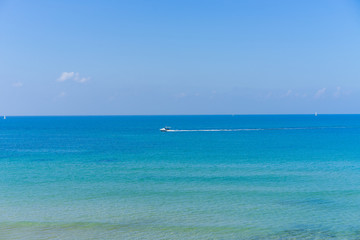 Obraz premium Calm water with a boat in the distance at the beach in Tel Aviv, Israel