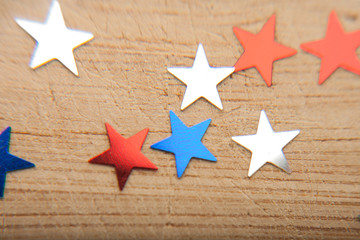 Fototapeta na wymiar Confetti stars on wooden background. 4th July, Independence day, card, invitation in usa flag colors. View from Top , empty space.