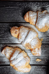  croissants on dark wooden background close-up top view