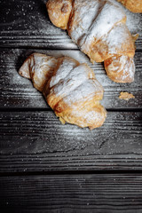 three croissants on dark wooden background close-up top view