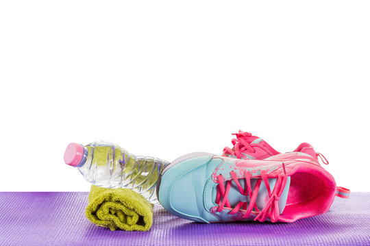Women's Sports Shoes, Water Bottles, Towels on a fitness pad ,isoalted on white ackground with clipping path.