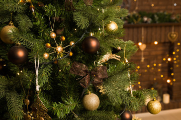 Christmas tree decorated with toys in brown with blurred lights in the background.