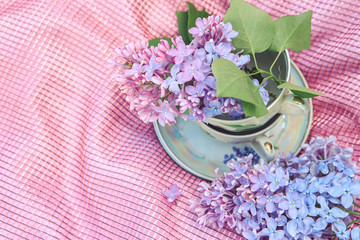 Obraz na płótnie Canvas Tea Cup with saucer and flowers, garden tea set with lilacs