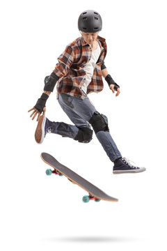 Teenage skater boy with protective equipment jumping