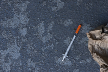 Dirty drug addict needle discarded on city sidewalk