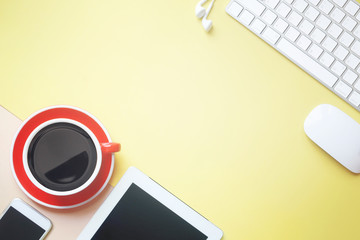 Desk with notebook, computer keyboard, mouse, coffee cup, copy space tablet
