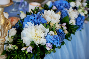 The table of young. Composition of hydrangeas, white tablecloth. White-blue gamma