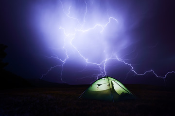 Incredible sky with lightning and tent camp. Danger tourism concept