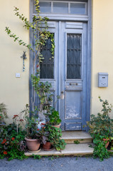 Fototapeta na wymiar Blue door in Mediterranean style. Traditional greek door in Cyprus. Vintage background, texture. Copy space. Old wooden door in Nicosia, with green plants