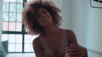 Beautiful cheerful Afro American woman in lingerie posing at home.