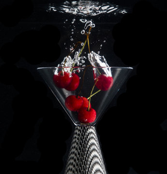 red cherries in a cocktail glass under water