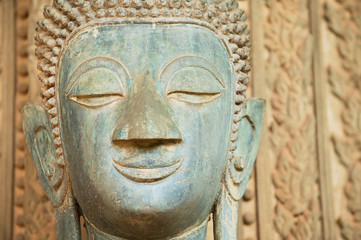 Fototapeta na wymiar Face of an ancient Buddha statue located outside of the Hor Phra Keo temple (former temple of the Emerald Buddha) in Vientiane, Laos.
