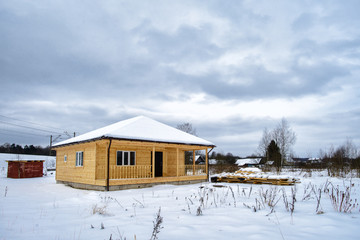 Snowy countryside. Modern wooden house in the field