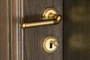 Obraz premium door handle. Door lock with keys. Brown wooden door closeup. New house concept. Real estate