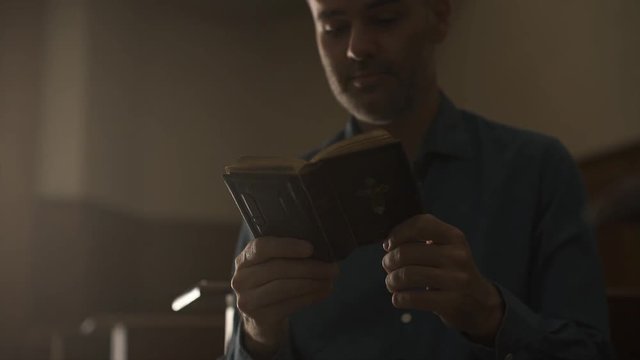 Man praying in the Church and reading the Bible