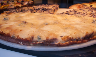 Slice of pizza with Gorgonzola exposed in a bakery