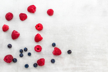blueberries and raspberries on a gray background with a copy space