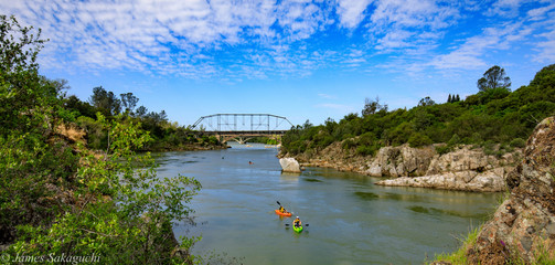 Fototapeta na wymiar Kayker on river with bridge