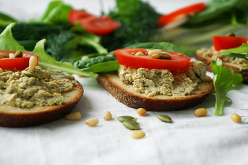 Vegan and vegetarian sandwiches with tofu paste, greens, tomatoes, pine nuts,   pumpkin seeds and lettuce.