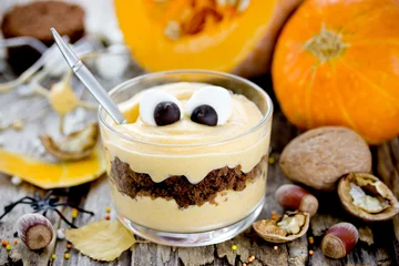 Zelfklevend Fotobehang Halloween monster dessert with marshmallow eyes from pumpkin cream and chocolate cookies in a glass, Halloween treats idea for kids © san_ta