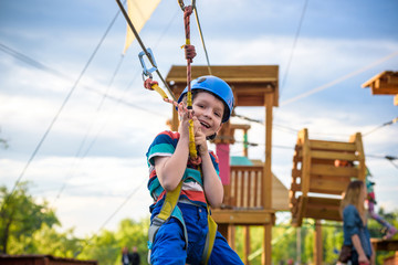 Little cute boy enjoying activity in a climbing adventure park on a summer sunny day. toddler...