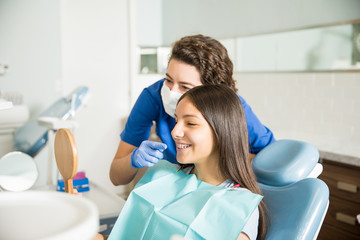 Dentist Showing Braces To Teenage Girl In Mirror At Clinic - obrazy, fototapety, plakaty