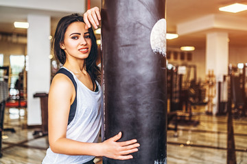 Sporty girl near punching bag in the gym