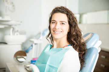Portrait Of Smiling Young Woman Sitting At Clinic