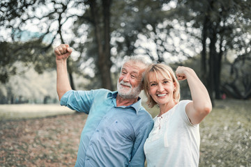 Happy elderly senior couple in park with good health action concept