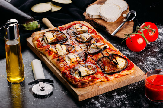 Bright pizza with vegetables on wooden board