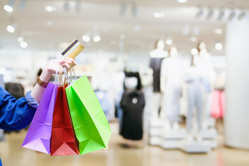 Young beautiful girl with shopping bags and credit card doing shopping in the mall