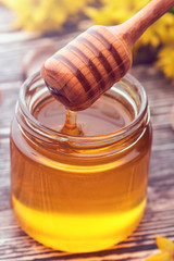 small glass jar with liquid honey
