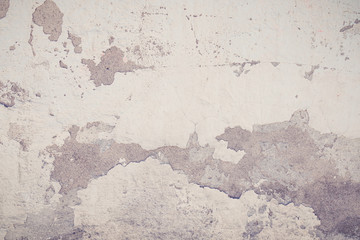 Old grungy wall with damaged plaster background texture.