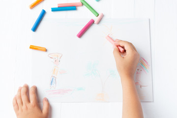 A girl draws a crayon, a pastel, a journey through the sea. Ship, sailor, boy, palm, sea