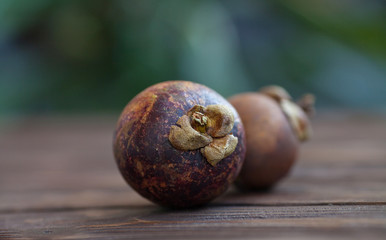 Fototapeta premium Purple mangosteen or Garcinia Mangostana, known simply as Mangosteen. Wooden background.