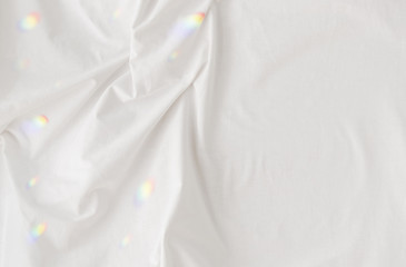 clean  white fabric background with folds and prism reflections