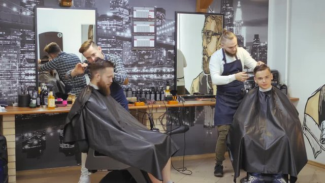 Hairdresser for men. Barbershop. Caring for the beard. Barber with hair clipper works on hairstyle for bearded guy barbershop background. Hipster lifestyle concept. Barber with clipper trimming hair