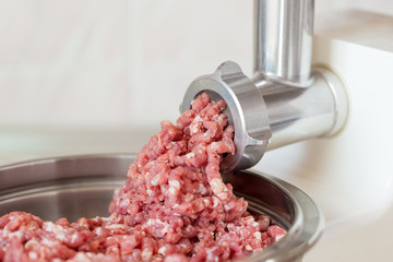 Process of meat grinding in the kitchen with mincing machine. - 211033198