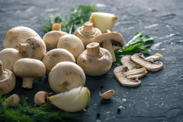 Fresh white Champions, green dill and ingredients on the dark kitchen table. Concept of cooking mushroom dishes