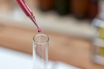 Researcher is dropping the reagent into test tube.Scientist working at the laboratory.