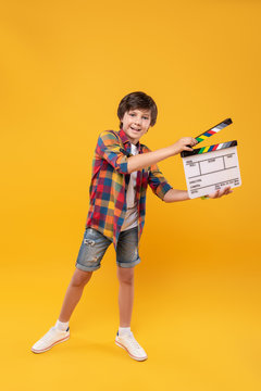 Future producer. Cheerful dark-haired boy smiling and holding a table