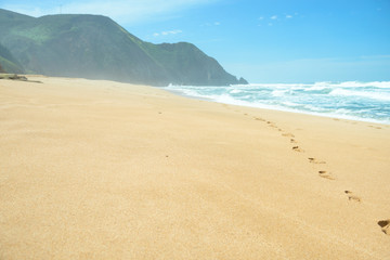 Footprints on deserted empty beach