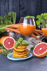 Juice from fresh carrots and grapefruit in a glass and fragrant pancakes for breakfast. vitamin drink for a healthy diet. Vitamins in food. Copy space,