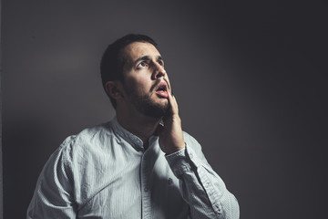 worried man looking up with his hand on his face