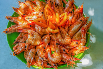 Delicious deep fried shrimp, on a green plate on a wooden table, copy space for text, view from above.